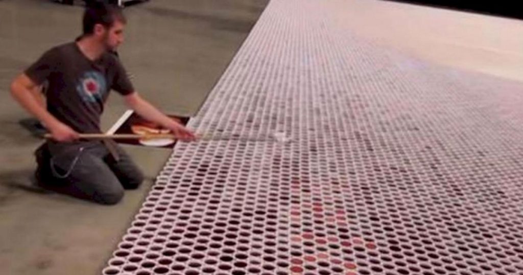 Il aligne plus de 66 000 verres sur le sol. Lorsque la caméra dézoome, c’est hallucinant!
