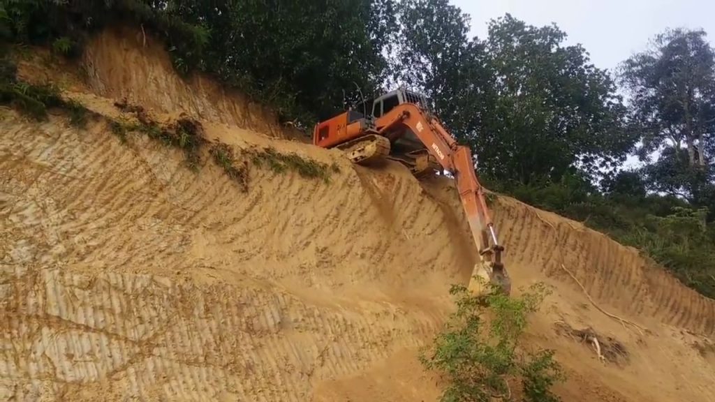 Il descend une paroi avec une pelleteuse
